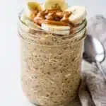 Creamy peanut butter banana overnight oats in a clear glass jar.