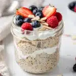 Creamy high protein overnight oats in a jar with berries and almonds.