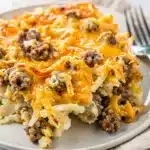 Creamy crockpot sausage hashbrown casserole with a golden cheese crust.
