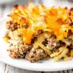 Creamy crockpot sausage hashbrown casserole with cheese and chives in dish