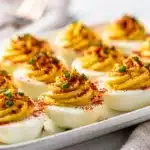 Classic deviled eggs recipe with creamy filling and paprika chive garnish.