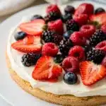 Easy Berry Cheesecake Fruit Pizza with fresh fruit on a sugar cookie crust.
