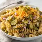 Creamy dill pickle pasta salad with cheddar cheese and fresh herbs