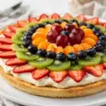 Classic fruit pizza with creamy frosting and fresh colorful fruit on sugar cookie crust