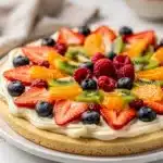 Colorful fresh fruit pizza on sugar cookie crust with cream cheese frosting