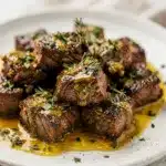 Sizzling garlic butter steak bites seared golden brown in a skillet.