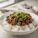 Homestyle Korean ground beef bowl with rice, scallions, and sesame seeds.