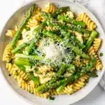 Lemon parmesan asparagus pasta salad in a white ceramic bowl.