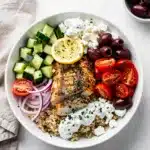 Mediterranean chicken bowl with quinoa, fresh vegetables, feta, and tzatziki sauce.