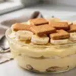 Old fashioned banana pudding with creamy custard and vanilla wafers in a glass bowl.