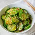 Spicy Asian cucumber salad recipe with chili crisp and sesame seeds.