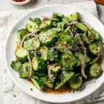Spicy Asian cucumber salad with chili sesame dressing and toasted sesame seeds