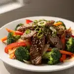 Tender teriyaki beef stir fry with broccoli and colorful vegetables in glossy sauce.