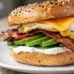 High protein bagel egg sandwich with avocado bacon and melted cheese