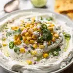Creamy chilled street corn dip with cotija cheese in a rustic bowl.