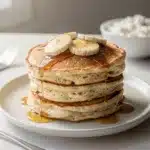 Fluffy cottage cheese banana pancakes with fresh fruit and maple syrup.