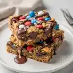 Fourth of July monster cookie bars with M&M's and chocolate chips on a wooden table.