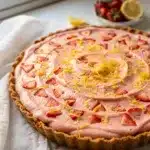 Frozen strawberry lemonade pie slice with creamy filling and fresh fruit garnish.