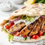 Juicy grilled chicken pita wrap with tzatziki sauce and fresh vegetables.