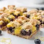 Golden lemon blueberry crumb bars on white plate, homemade.