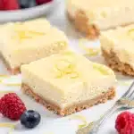 Lemon Icebox Cheesecake Bars with fresh blueberries and powdered sugar