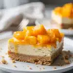 No bake peach cheesecake bars with graham cracker crust and fresh mint garnish