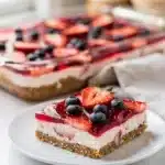 Patriotic strawberry pretzel dessert bars with creamy cheesecake layer.