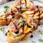 Peach prosciutto bruschetta with mozzarella and balsamic glaze on toasted baguette