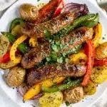 Sausage and veggie bell pepper sheet pan bake with roasted potatoes and herbs.