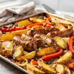 Crispy sheet pan Italian sausage and potato bake with peppers and onions.