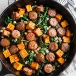 Smoky sausage sweet potato spinach hash, crispy browned caramelized skillet meal.