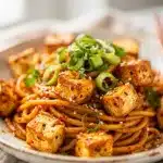 Spicy miso sesame noodles with crispy tofu and green onions.
