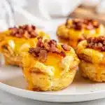 Golden brown turkey bacon egg muffin cups with cheese and bell peppers.