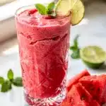 Creamy watermelon mint refresher smoothie in clear glass condensation.
